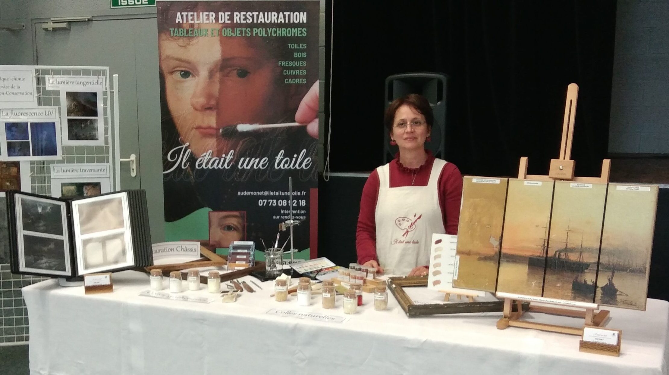 Salon-La restauratrice de tableaux devant son stand de l'atelier Il était une toile